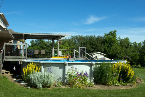 A backyard deck and above ground swimming pool.