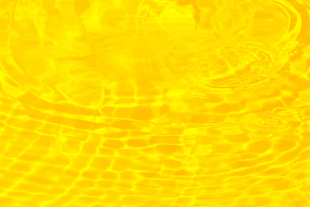 istock Defocus blurred transparent gold colored clear calm water surface texture with splashes reflection. Trendy abstract nature background. Water waves in sunlight with copy space. Yellow  watercolor shine. 1729615515