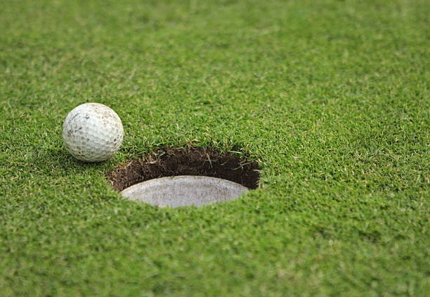 sale balle de golf prête à être putted dans le trou sur le green. - skill sphere leadership simplicity photos et images de collection