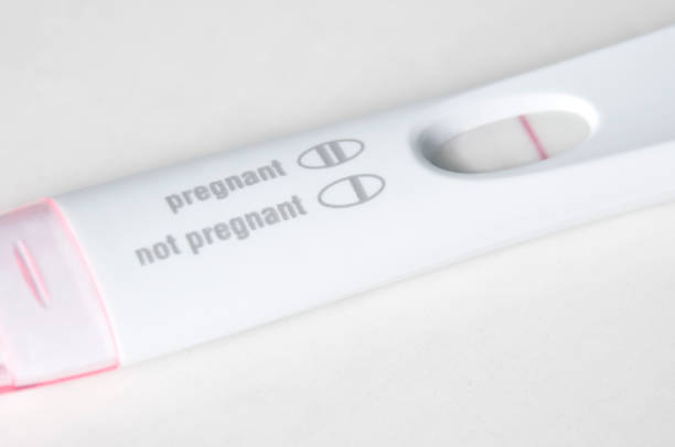 A pregnancy test closeup on a white bathroon countertop with the results not pregnant.