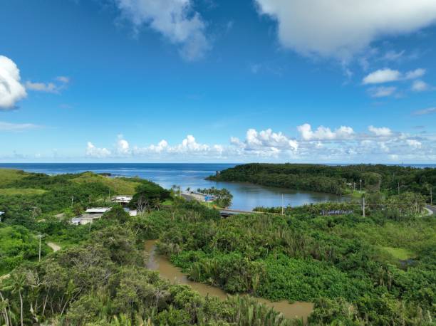 Agfayan River that flows out to one of two bays at Inarajan, Guam.  Off in the distance is Bear Rock, a popular landmark and tourist attraction