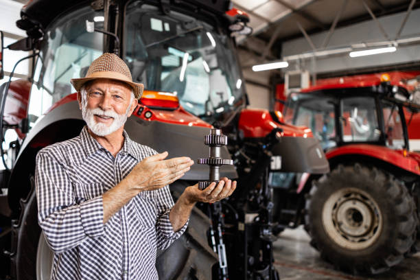 istock Farmer holding spare parts for tractor machine. 1729621542