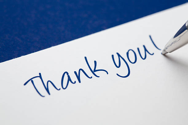 Thank you card on blue In the process of writing a thank you card.   See also:  thank you stock pictures, royalty-free photos & images