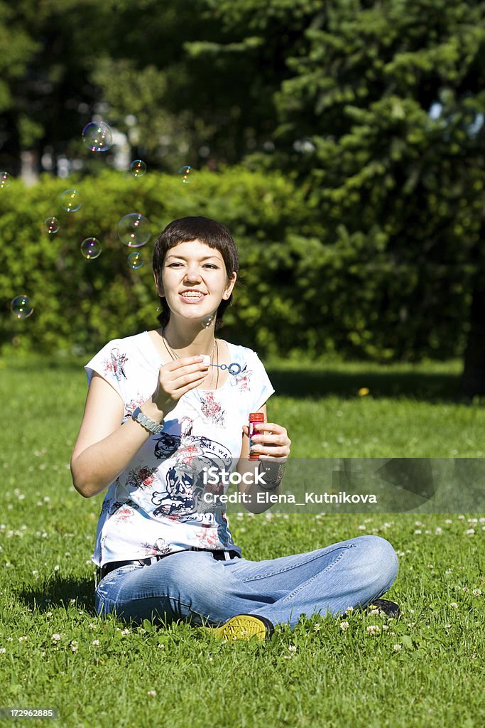 Lächelnd Mädchen auf dem Rasen mit soap bubbles - Lizenzfrei Zahnspange Stock-Foto