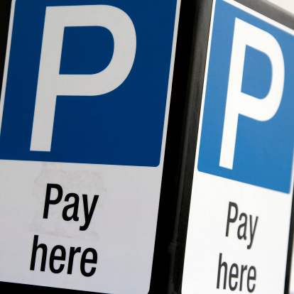 A 'pay here' sign in a car park.