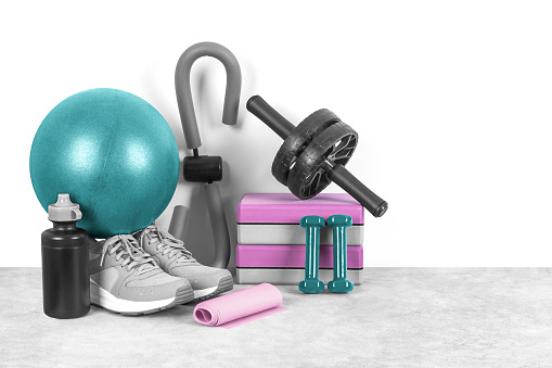 Different sports equipment on a gray background, front view, copy space. Home workout. Fitness and activity.