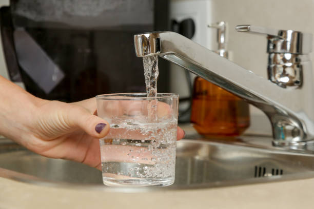 istock Filling up a glass with fresh drinking water from kitchen faucet 1729640283