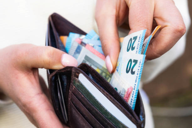 Taking Euros from a wallet Macro image as a woman takes Euro banknotes from a leather wallet. european union currency european union euro note currency europe stock pictures, royalty-free photos & images