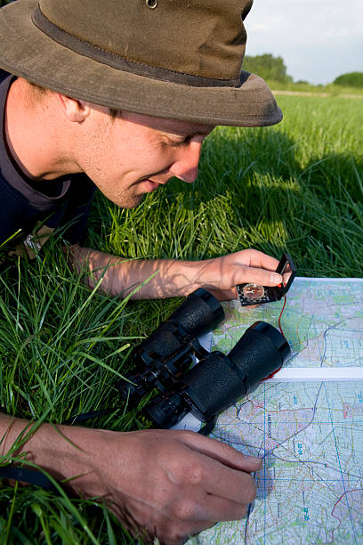 junger mann erkunden der karte mit kompass - boy scout orienteering compass map stock-fotos und bilder