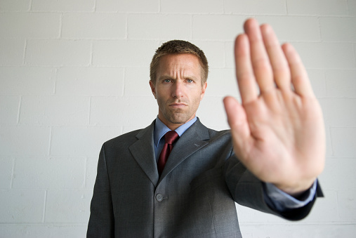 Businessman holds up his hand in a stop gesture