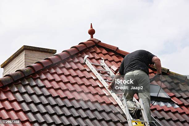 Foto de Um Homem No Telhado Limpando Os Azulejos Com Lavador Por Pressão e mais fotos de stock de Telhado