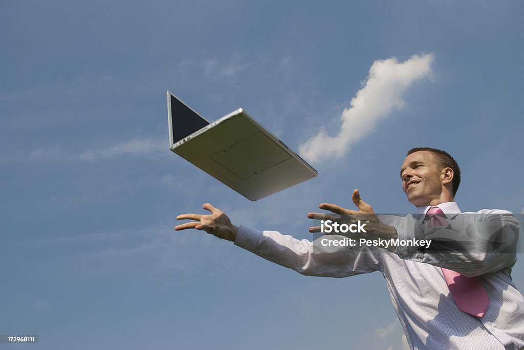 Happy Businessman Reaches Out for Cloud Computing on Laptop Businessman reaches out with a smile to his floating laptop Laptop Stock Photo