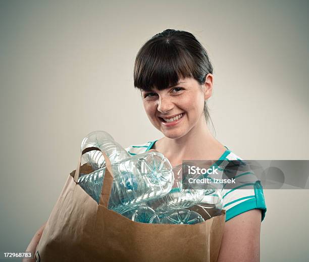 Foto de Jovem Mulher Com Garrafas De Plástico Em Um Saco De Papel e mais fotos de stock de Lixo