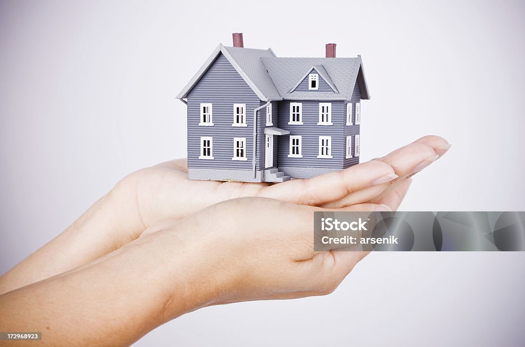 Real estate market Hands holding miniature model house. Architectural Model Stock Photo