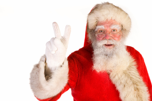Santa gives the peace sign and looks at camera