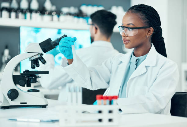 istock Scientist, woman and microscope or blood test, research and bacteria, virus or vaccine solution in medical study. Professional doctor or science student with glass tube, biotechnology and laboratory 1729701916