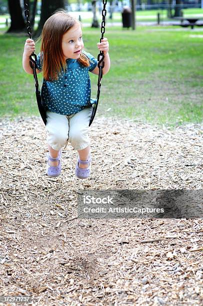 Foto de Menina Sentada Em Um Balanço No Parque e mais fotos de stock de 2-3 Anos - 2-3 Anos, Aluno de Jardim de Infância, Atividade Recreativa