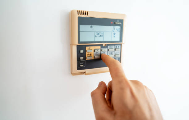 istock Man's hand adjusting wall-mounted digital thermostat. 1729713446