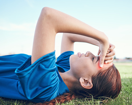 Sports, headache and woman on a baseball field with fatigue, burnout or health, crisis and mistake. Fitness, migraine and softball player on ground with pain, vertigo or stress, problem or accident