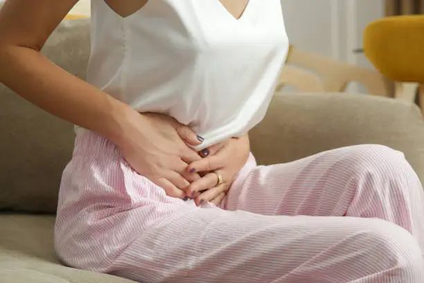 Stomach pain. Woman having upset stomach or menstrual cramps. A young woman experiences abdominal pain in the apartment.