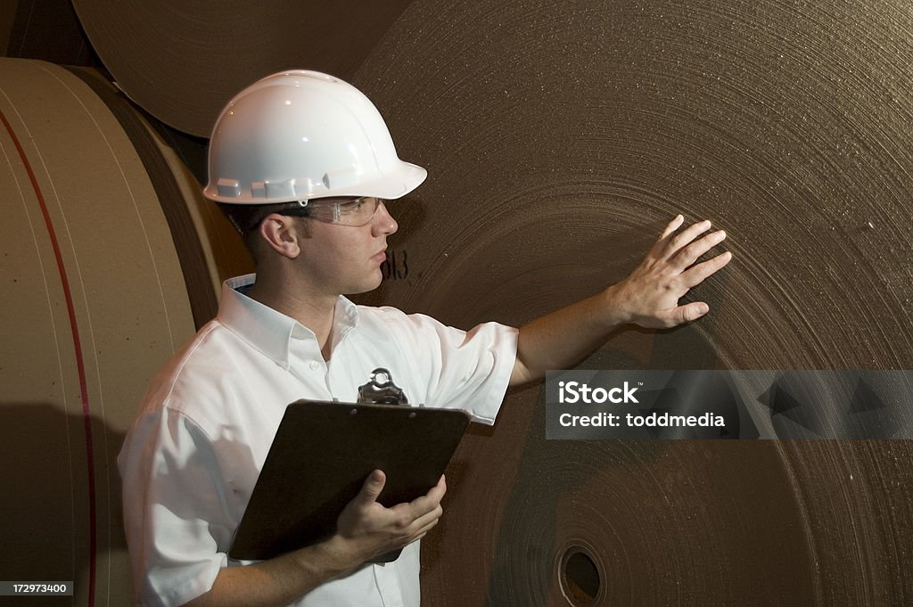 New Paper An engineer or Inspector checks a new roll of paper at a paper mill. Paper Mill Stock Photo