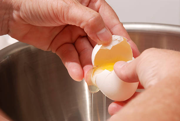 istock Hands Breaking Eggs into a Stainless Steel Mixing Bowl. 172973422