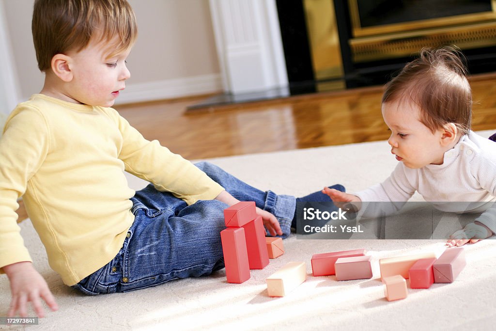 Brother and sister playing together Brother and sister playing with blocks. Baby - Human Age Stock Photo