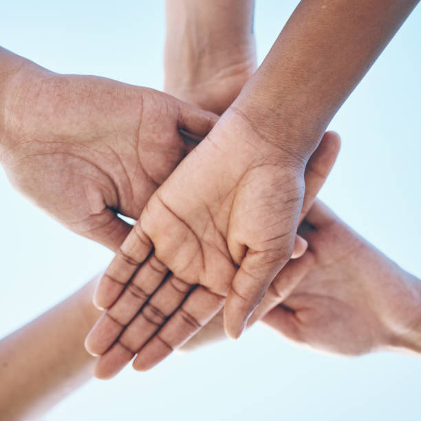 istock Blue sky, hands stack and together for team building motivation, group cooperation or community goals support. Closeup below view, synergy commitment and people collaboration, teamwork and solidarity 1729745653