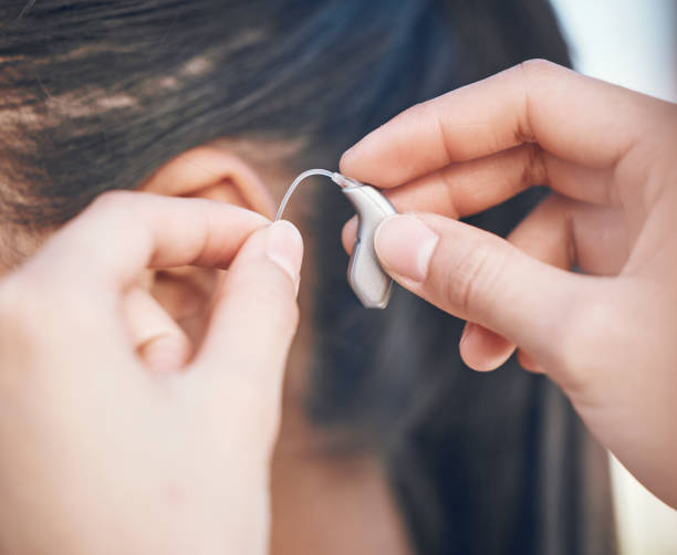 primo piano, mani e supporto per apparecchi acustici per la persona, aiuto per l'ascolto e attrezzature mediche. sanità, donna con disabilità e salute audio, innovazione clinica e dispositivo per le onde sonore o la comunicazione - human finger audio foto e immagini stock