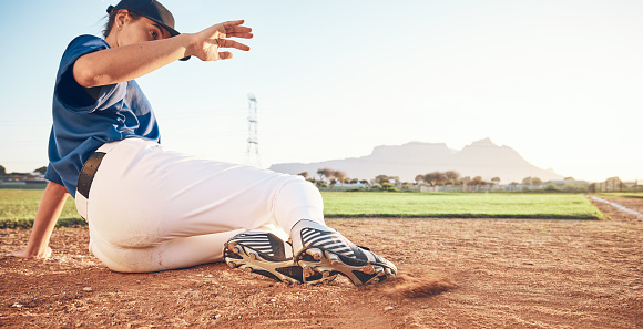 Slide, baseball action and player in dirt for game or sports competition on a pitch in a stadium. Man, ground and  tournament performance by athlete or base runner in training, exercise or workout