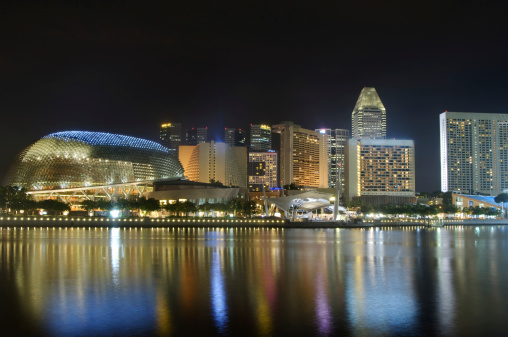 Singapore - Feb 25, 2020. Famous tourist destination - Marina Bay Sands , Shoppes mall, ArtScience museum and Helix bridge in Marina bay, Singapore, on sunny day. Must-see landmarks of city-state, clear blue sky, azure waters. Iconic futuristic architecture and symbols.