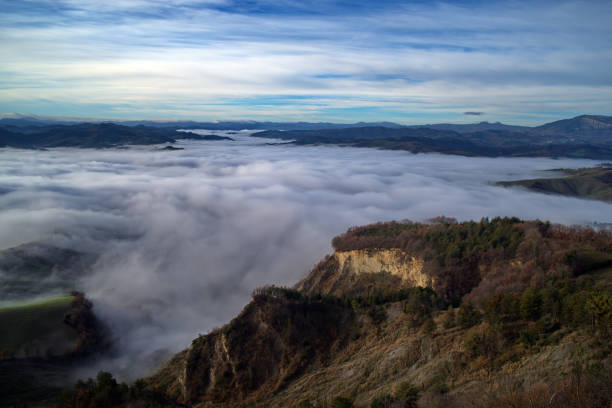 foggy morning in the Foglia river valley with the hills rising out of the sea of ​​fog