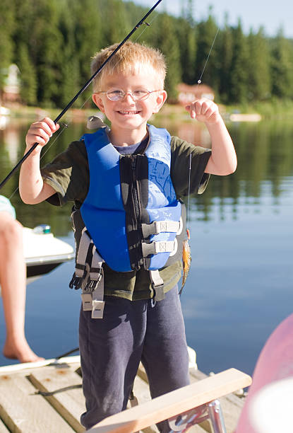 istock Little Boy Holding up a Fish that he Caught 172975535