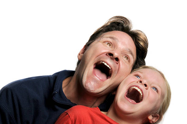 Father and Daughter A father and daughter laugh together. Studio lighting, white background. child laughing hysterically stock pictures, royalty-free photos & images