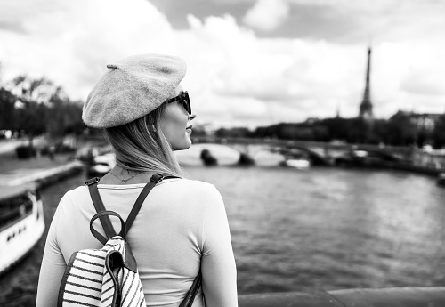 Young woman enjoying the view of the Eiffel Tower and River Seine in Paris, France