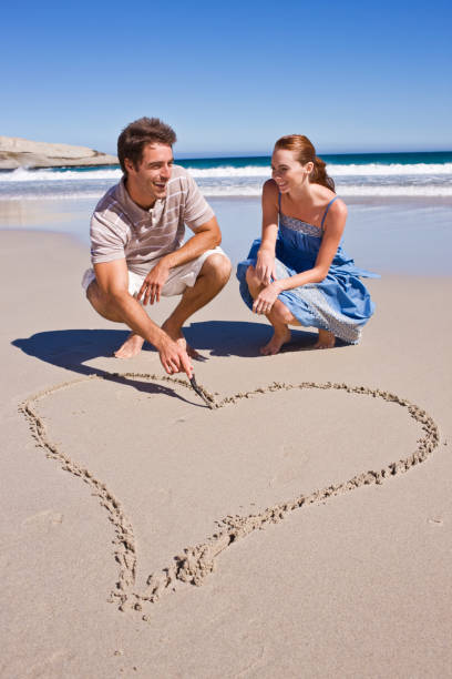 istock Couple making heart shape on sand at beach 172975953