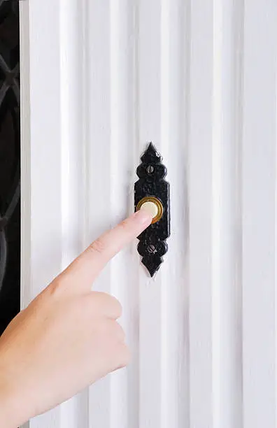 a finger pushes a doorbell