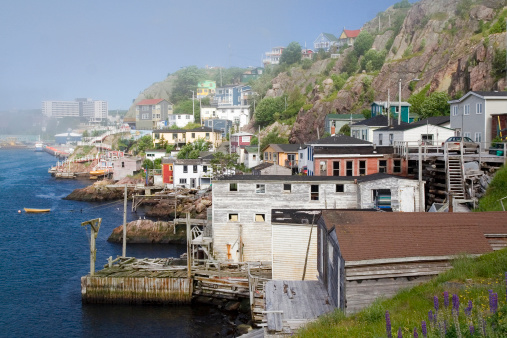 Some old, run-down fishing homes and docks on the Outer Battery of St John's, Newfoundland, Canada on a 'soft' (misty) day. The city is in the background.