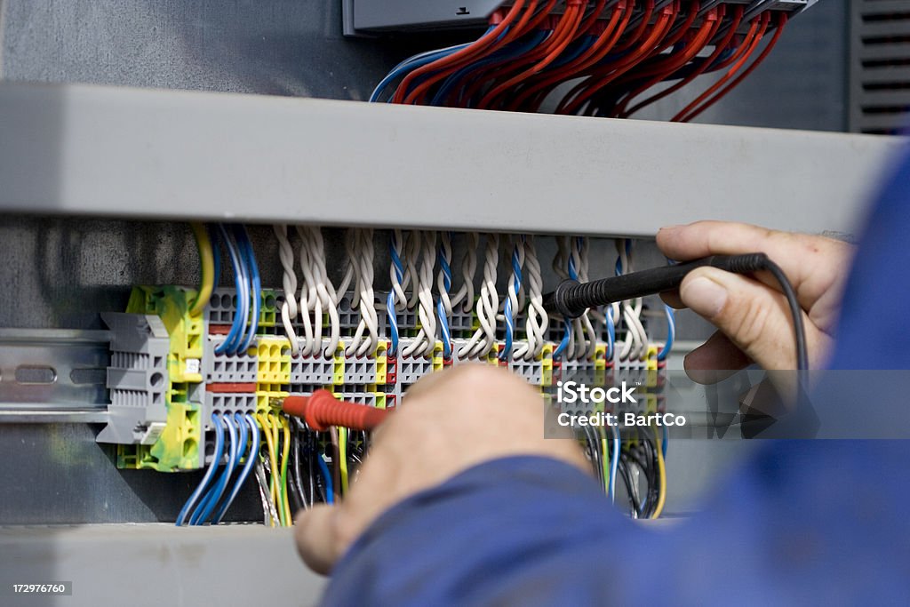 Electrician at work with his instrument of measurement. "If you want more related images with a construction worker (with tools), click here." Power Line Stock Photo