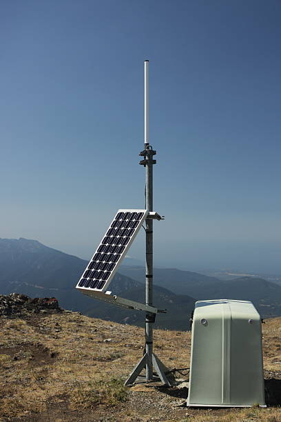 Solar Energy Dish Power Station Earthquake Monitor Solar electrical energy panel powers earthquake monitoring station on exposed wilderness mountain peak, including solar cell, antenna, tripod, and remaining equipment under weatherproof housing.  Pacific Northwest, Washington, 2008. seismology stock pictures, royalty-free photos & images