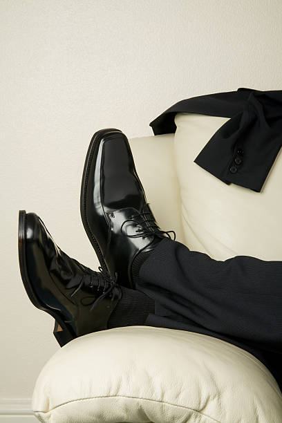 Businessman's feet on a couch stock photo
