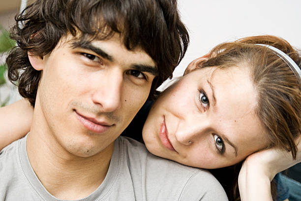 Young woman relaxing on man's lap, showing affection and closeness.