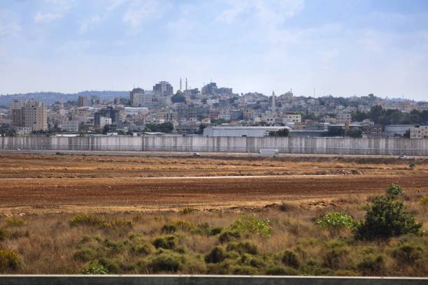 West Bank Barrier security wall separating Israel and Palestinian territory. Concrete wall along Green Line along Yitzhak Rabin Highway. Qalqilya town in background.