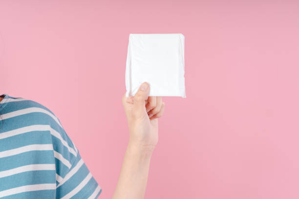 istock Female hands holding a sanitary pad on a pink background 1729775342