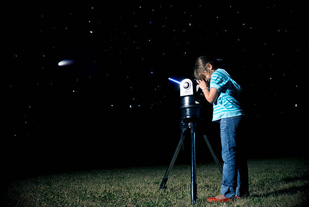 Comet "Young girl, out in a field, looking to a comet through a telescope. (Comet image coming from public domain NASA archives)See,too:" comet photos stock pictures, royalty-free photos & images