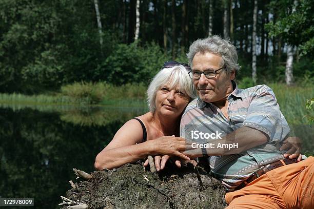 Foto de Feliz Casal Senior Sentado Em Frente De Um Lago e mais fotos de stock de 60 Anos - 60 Anos, 60-64 anos, 65-69 anos