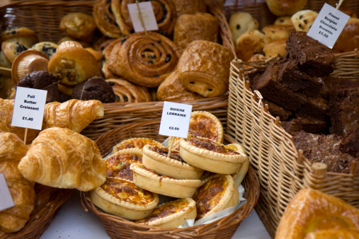 A variety of cakes and pastries on a market stall.