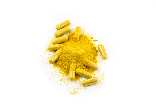 Capsules With Turmeric and Thistle on White Background.