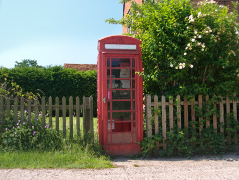 Old fashioned red phone box in the English country side.