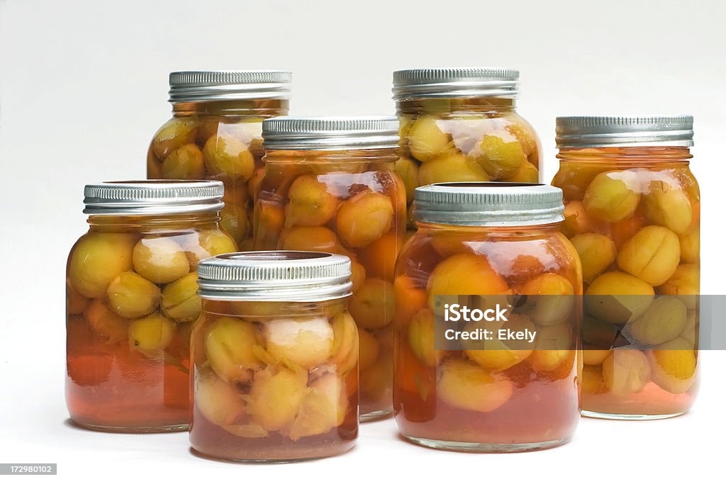 Standing  preserved  plums on glass jars with metal lids. Preserved Victoria plums in glass jars. Antioxidant Stock Photo